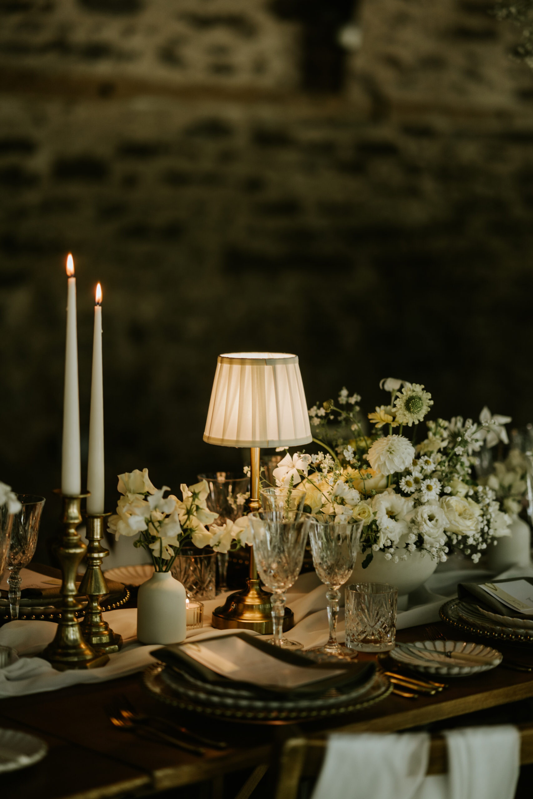 Venue styling with lamps, candlelight and floral bowl arrangements